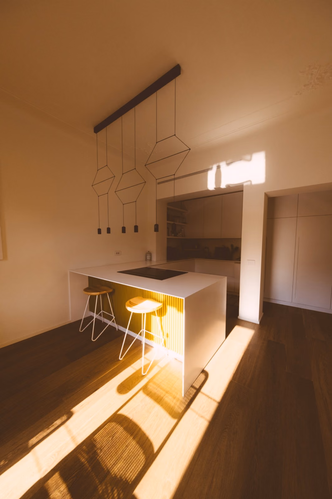 Cocina reformada con isla, muebles de madera y luz natural sobre la encimera